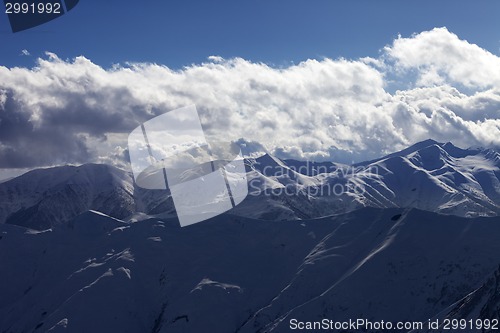 Image of Evening sunlight mountain with clouds and silhouette of paraglid