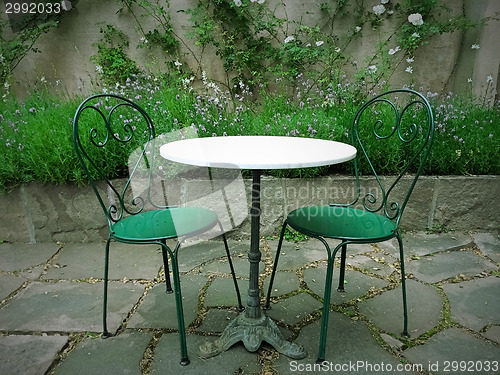 Image of Chairs and table in a magic summer garden 