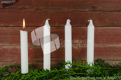 Image of Four advent candles at an old plank wall