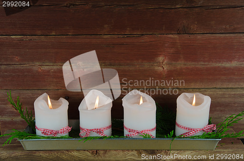 Image of Four advent candles at an old weathered red wall 