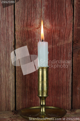 Image of Single candle in candlestick at old wall