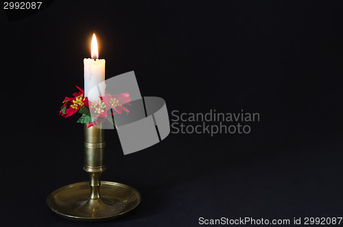 Image of Christmas decorated candle at a black background
