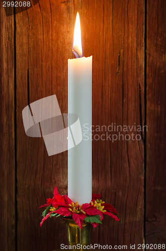 Image of Single burning candle with decorated candle-ring