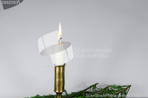 Image of One white candle at a white background