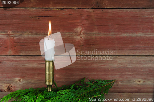 Image of Candle at old barn wall and green decoration