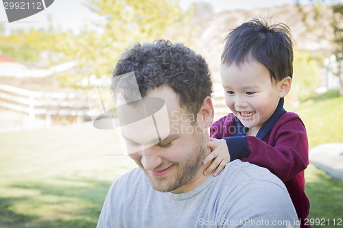 Image of Caucasian Father Having Fun with His Mixed Race Baby Son