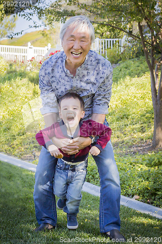 Image of Chinese Grandpa Having Fun with His Mixed Race Grandson Outside