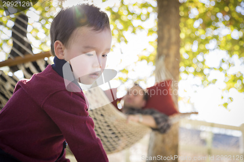 Image of Mixed Race Boy Having Fun While Parent Watches From Behind