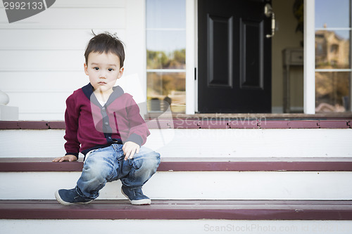 Image of Melancholy Mixed Race Boy Sitting on Front Porch Steps