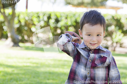 Image of Mixed Race Boy Playing Football Outside