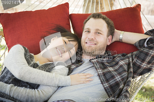 Image of Mixed Race Couple Relaxing in a Hammock