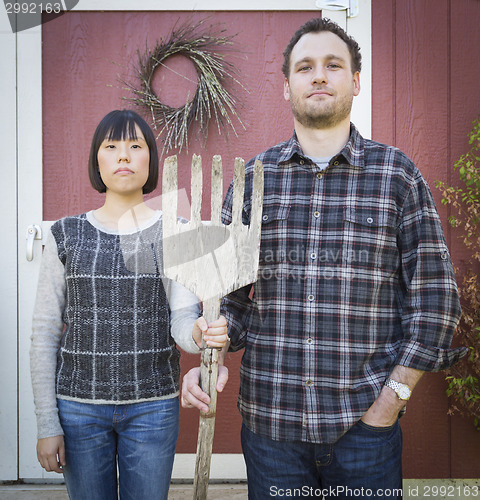 Image of Fun Mixed Race Couple Portrait Simulating the American Gothic Pa