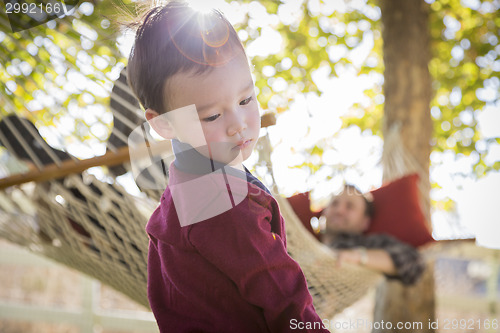 Image of Mixed Race Boy Having Fun While Parent Watches From Behind