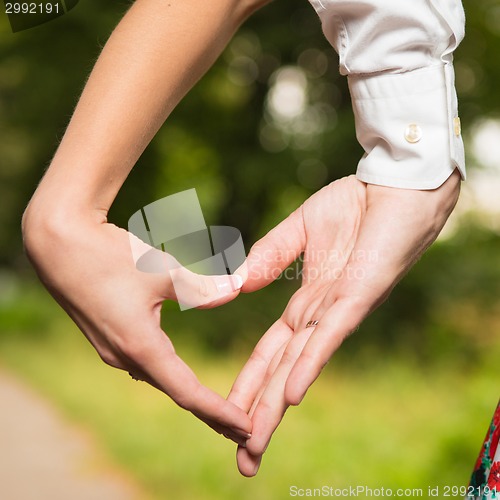 Image of Bride and groom standing together with heart