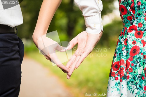 Image of Bride and groom standing together with heart