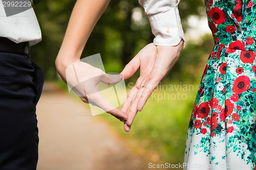 Image of Bride and groom standing together with heart