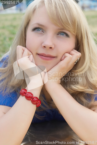 Image of Attractive woman lying on grass