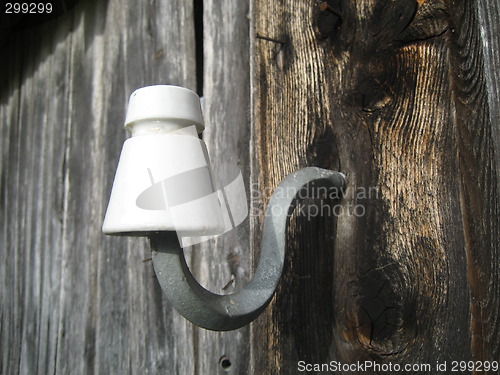 Image of Old power cable holder on farm house wall