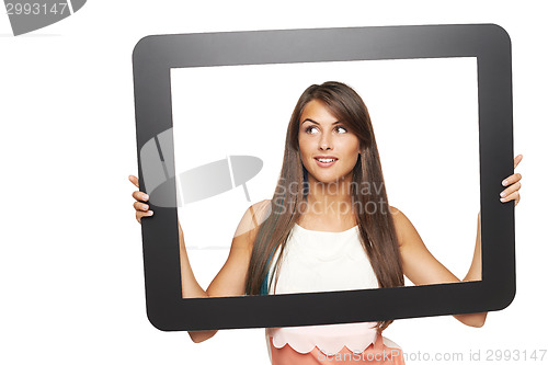 Image of Woman looking to side through tablet frame