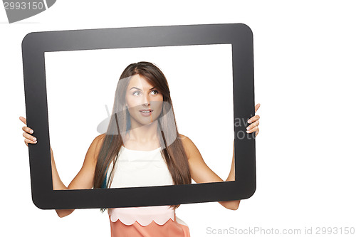Image of Woman looking to side through tablet frame