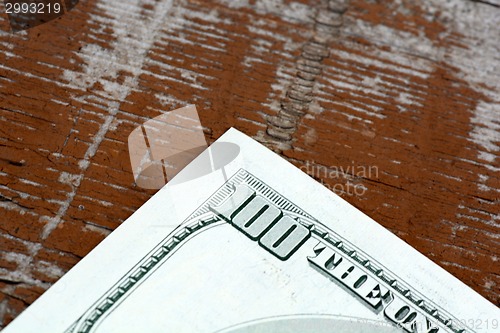 Image of Hundreds of US dollars on old wooden plank