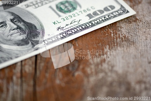 Image of Close-up of a $100 banknotes on wooden background