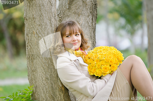 Image of Cute little girl with yellow roses saw a familiar