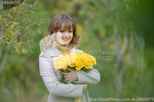 Image of Beautiful girl with a bouquet of yellow roses