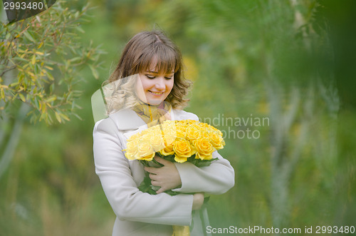 Image of Happy girl with a bouquet of yellow roses