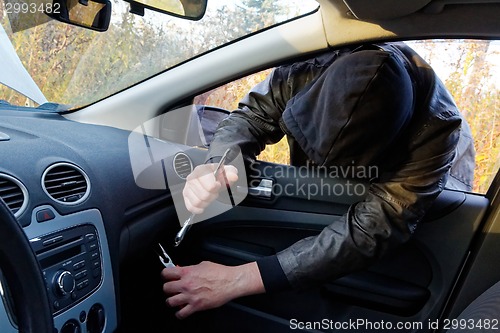 Image of Hooligan breaking into car