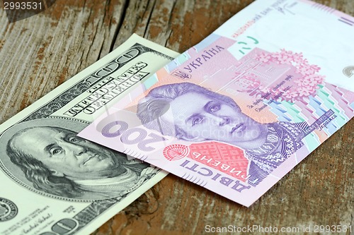 Image of dollars euro hryvnia banknotes on wooden background