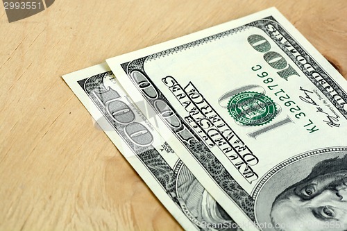 Image of Close-up of a 100 dollars banknotes on wooden background