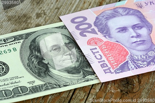 Image of dollars euro hryvnia banknotes on wooden background