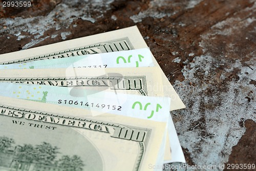 Image of Hundreds of US dollars and euro on old wooden plank