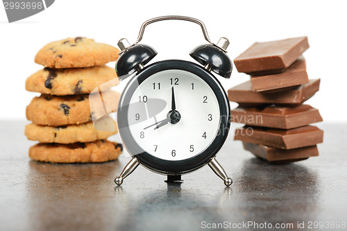 Image of Black alarm clock and sweets