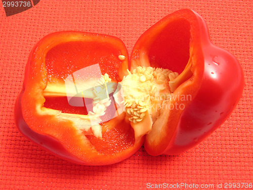 Image of Red pepper cutted into halves on a red placemat