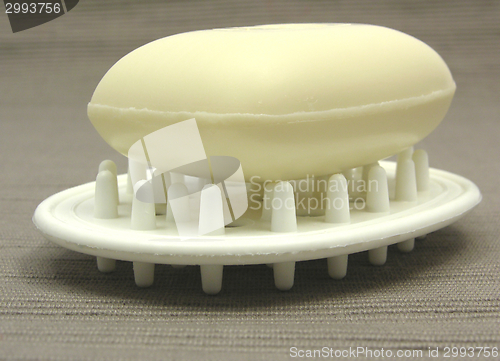 Image of Beige soap on a soap dish on a gray background