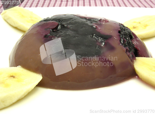 Image of Chocolate pudding with blueberries, banana and pieces of almonds