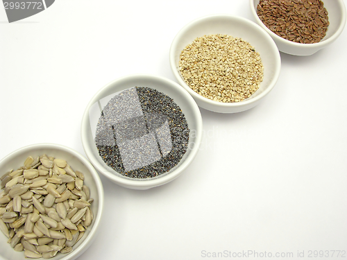 Image of Four bowl with different seeds on a white background