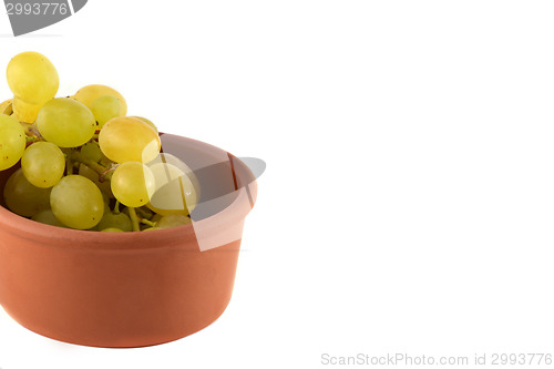 Image of Green grapes in wooden plate on white background