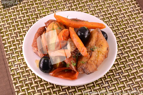 Image of Salad with sausage, cheese, carrots, over white plate