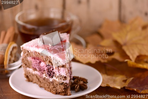 Image of cup of hot tea, sweete cake and autumn leaves