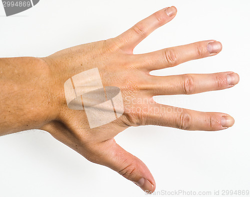 Image of Male person showing five fingers towards a grey scale wall