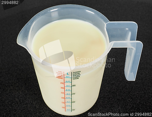 Image of Half a liter of white milk in a transparent measurement plastic 