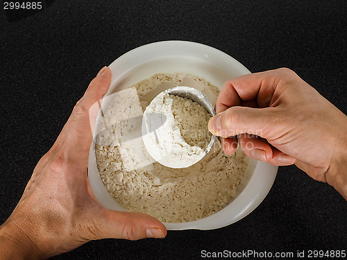 Image of Person using a measurement tool in a bowl of wheat flour