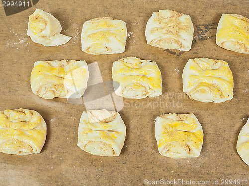 Image of Plaited cinnamon rolls on baking paper with egg wash