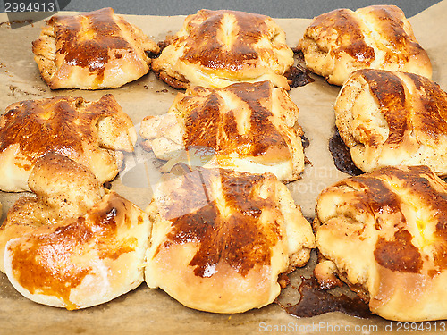 Image of Fresh made cinnamon buns plaited on baking paper