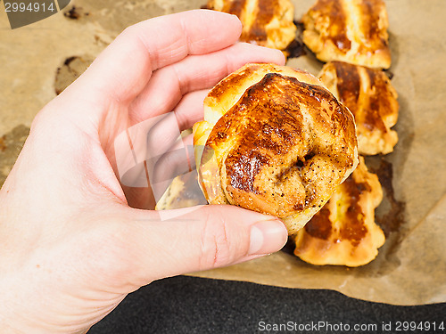 Image of Person holding a cinnamon bun over plaited buns