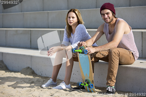 Image of Young skateboarding couple on a beach