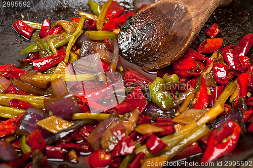 Image of fried chili pepper and vegetable on a wok pan